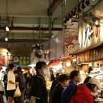 People browsing stalls in a busy indoor market.