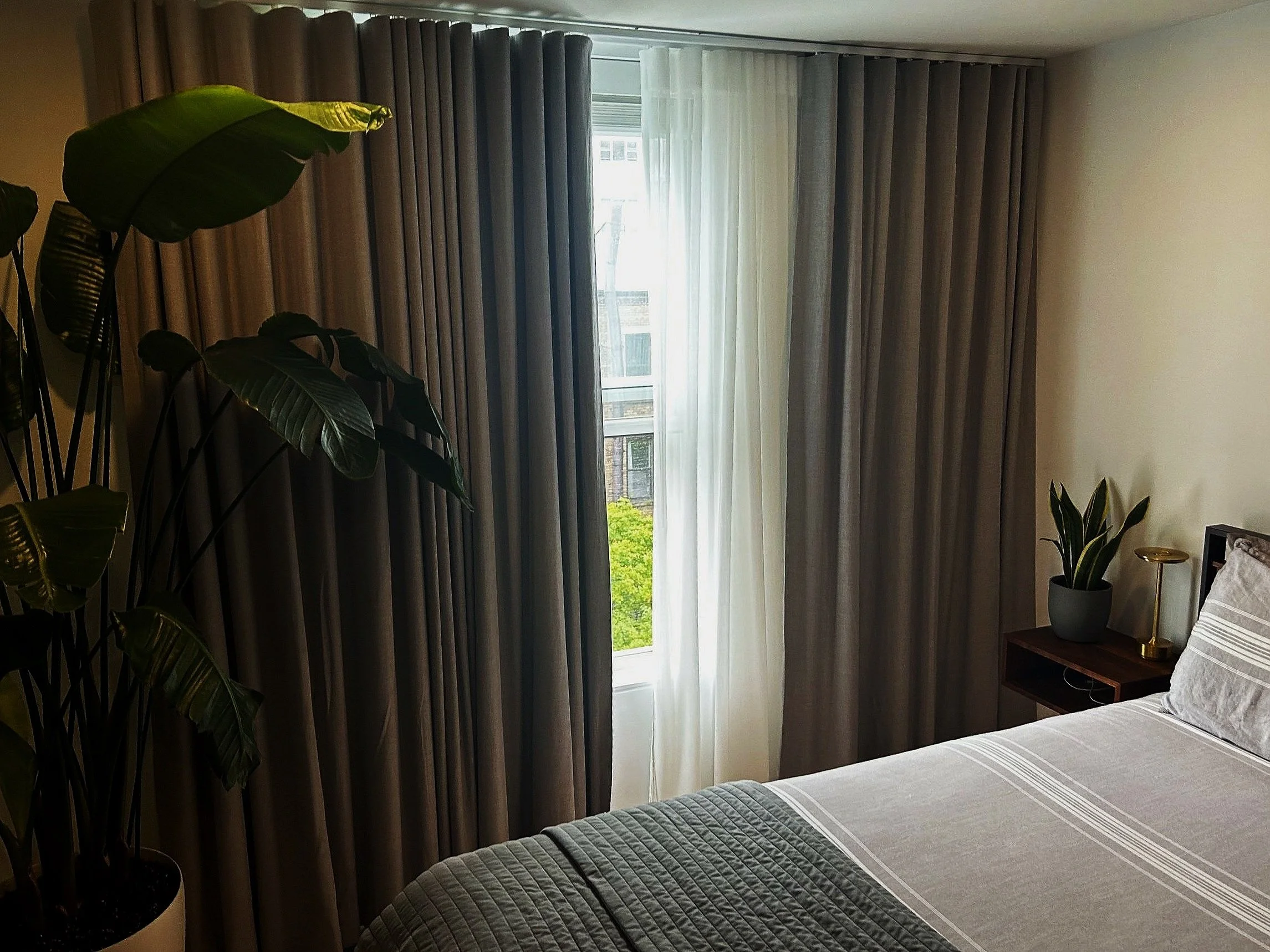 Hotel room sleep setup with comfortable bed and blackout curtains