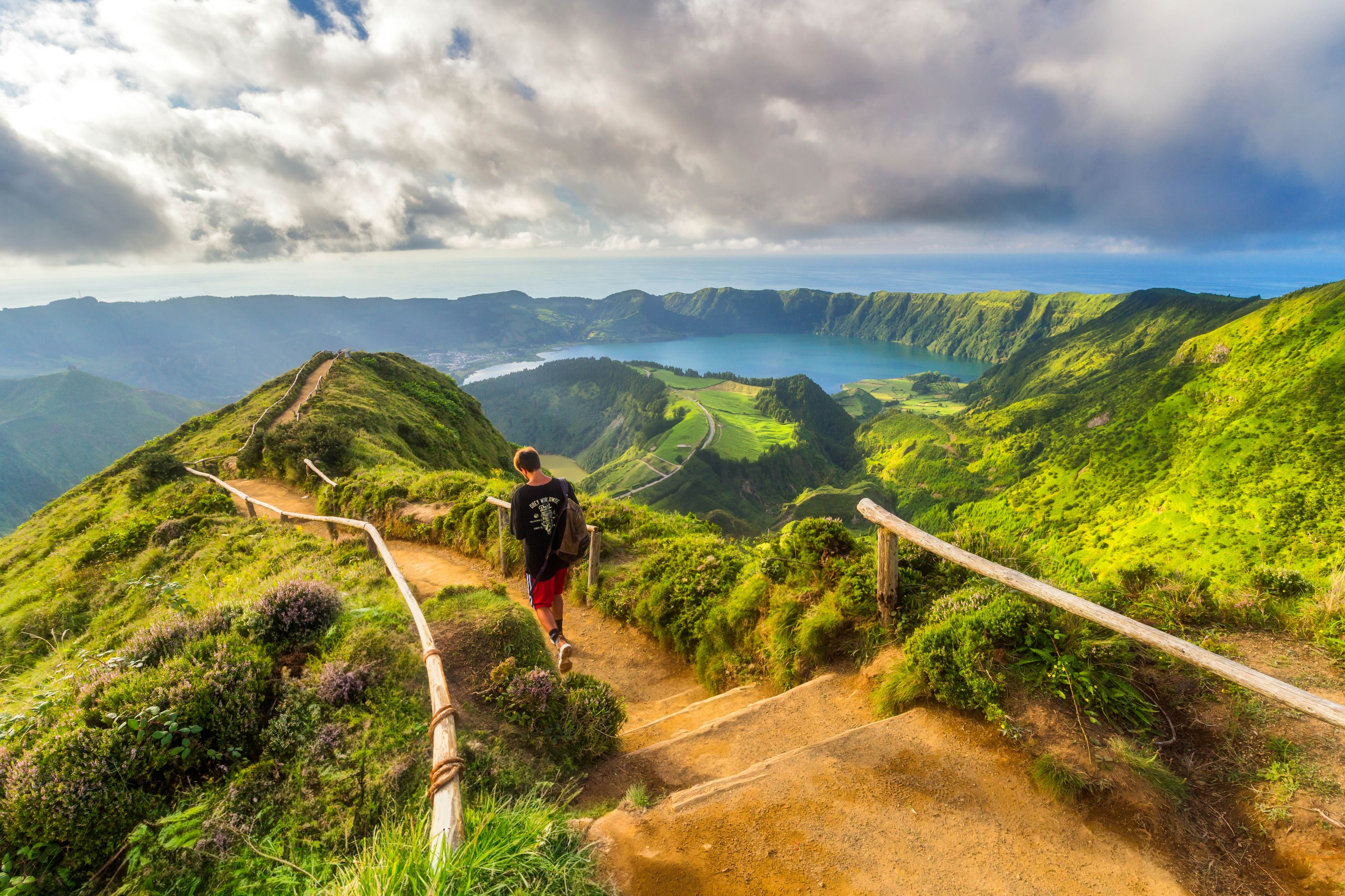 Traveler following a marked island hiking trail beside the ocean